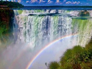 Iguazu waterfall with a rainbow in front of it.