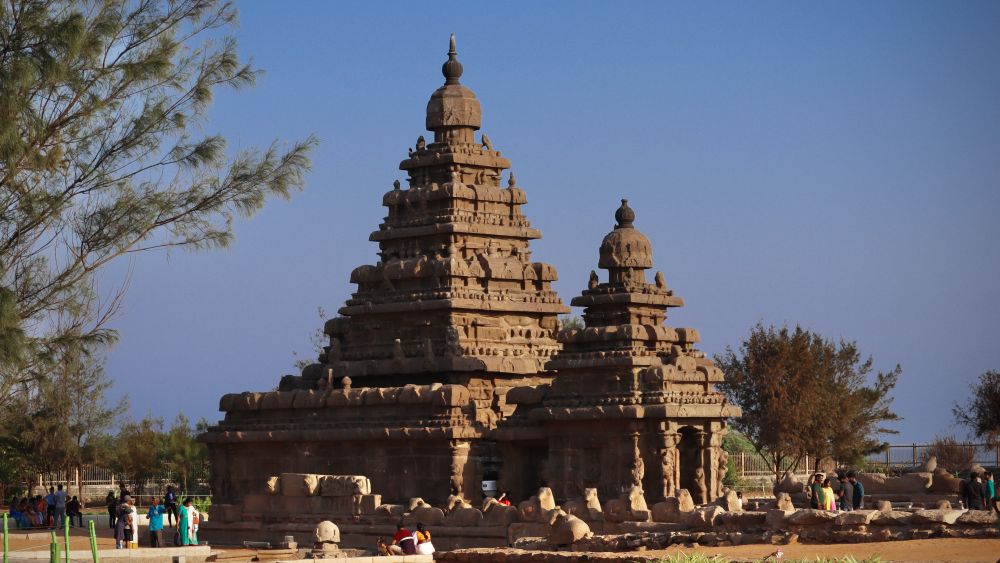 An intricately-carved temple with a tall pointy tower and a smaller tower in front of it.