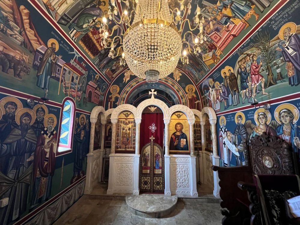 Interior chapel with walls and ceiling covered with bright frescoes.