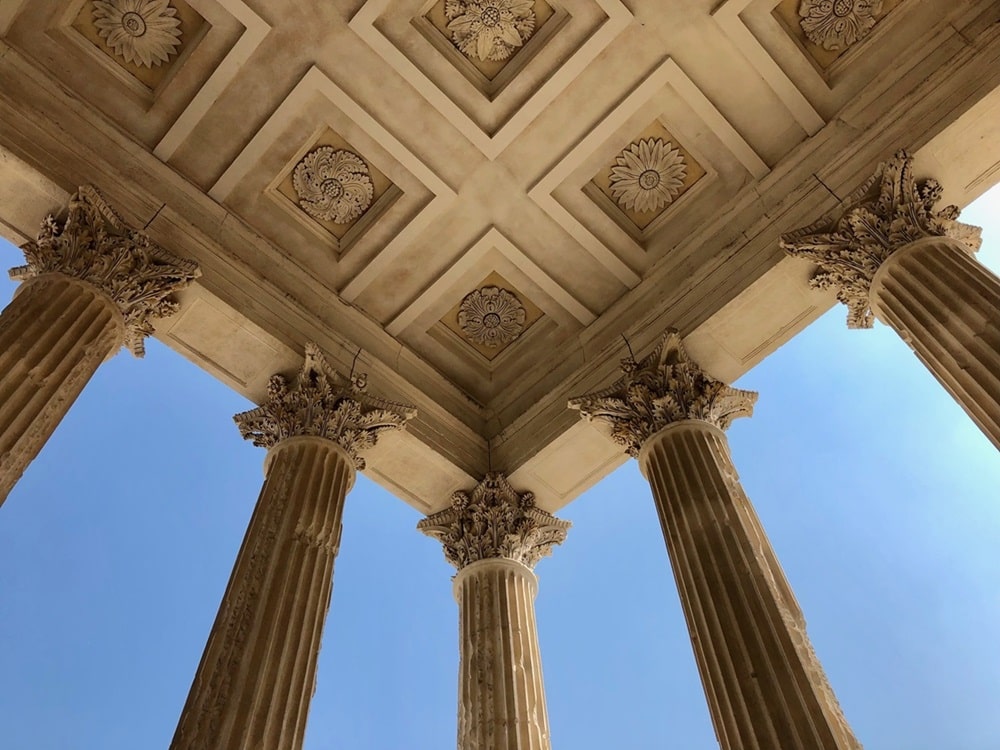 Columns supporting a ceiling divided into squares with detailed carving.