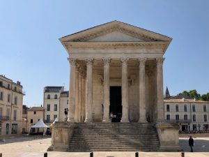 Classical temple seen from the front, with six corinthian columns supporting a triangular pediment.