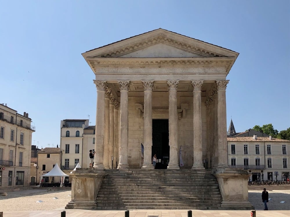 Classical temple seen from the front, with six corinthian columns supporting a triangular pediment.