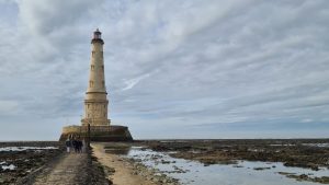 The lighthouse as seen from near the end of the walkway - tidal pools and rocks on either side.