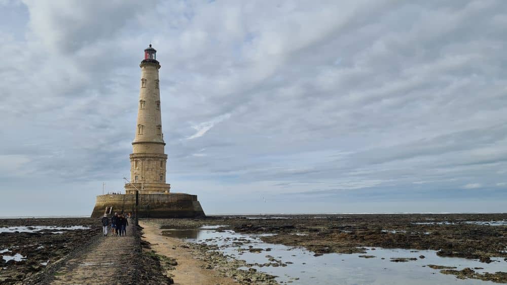 The lighthouse as seen from  near the end of the walkway - tidal pools and rocks on either side.