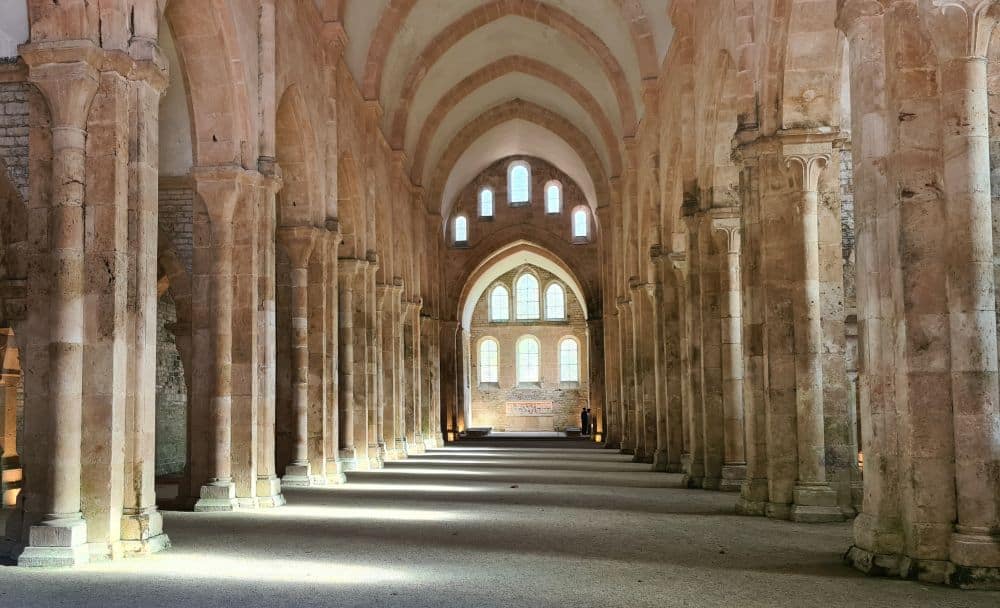 The nave of the church, large with gothic arches, columns along both sides, and windows at the far end.