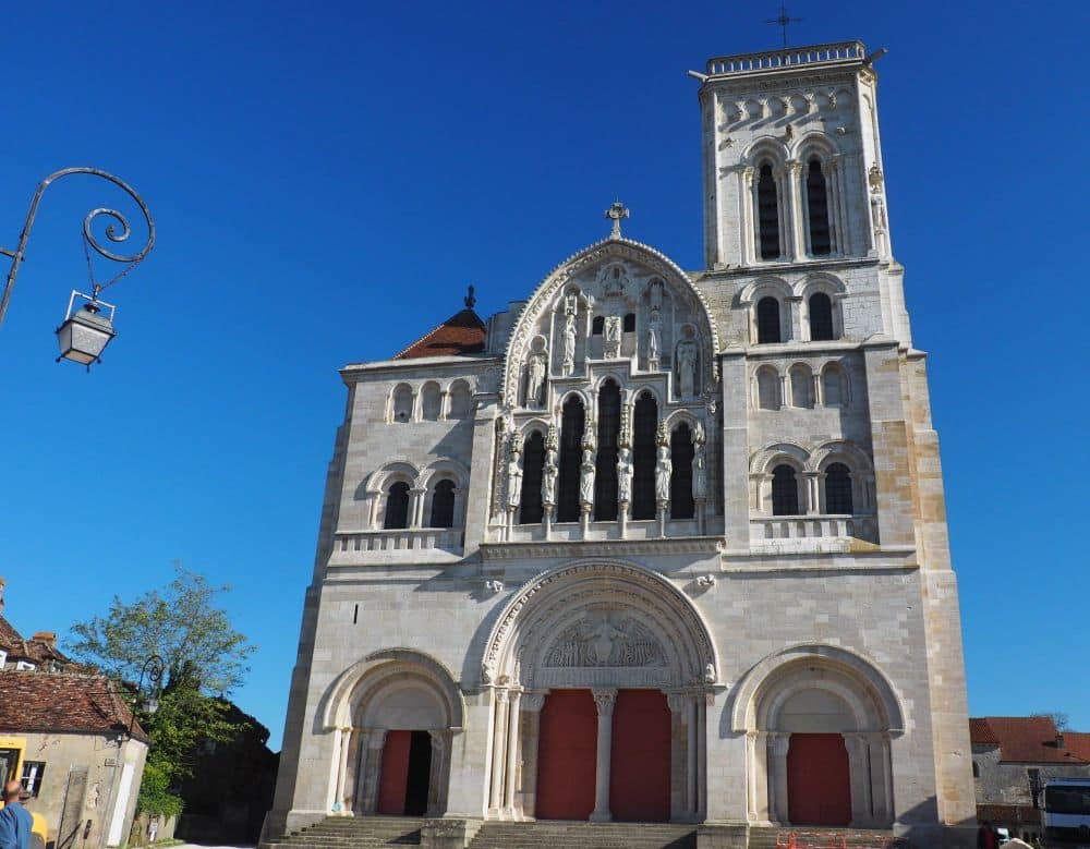 the front of the church has 3 arched portals and a square tower on the right.