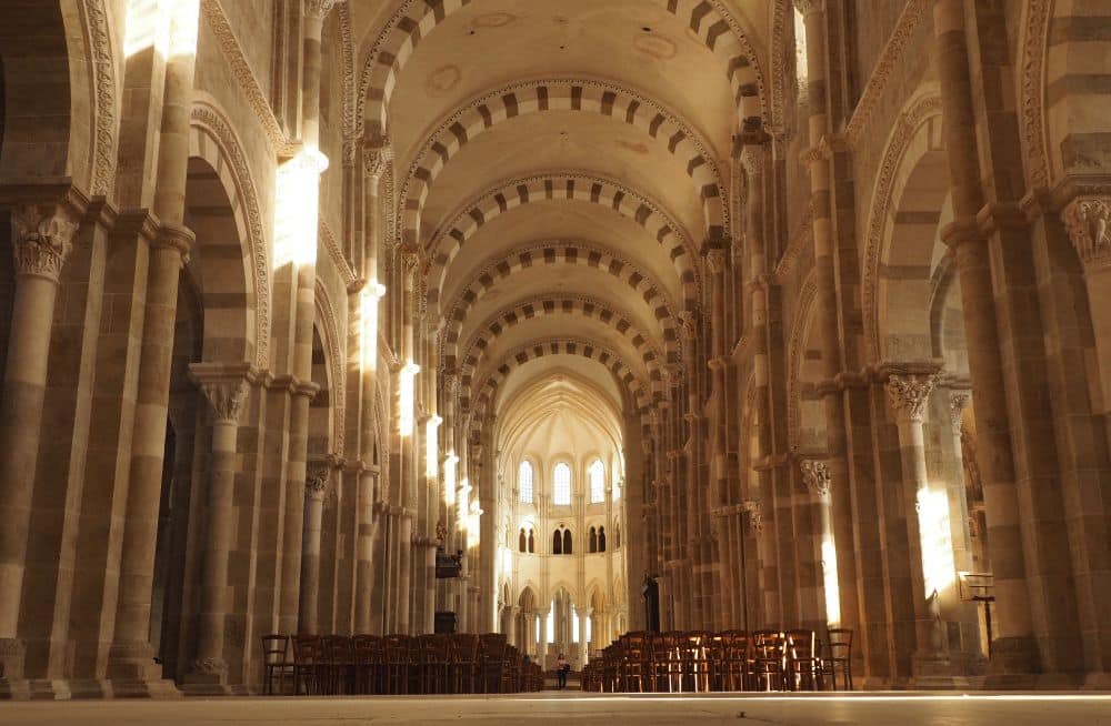 A view down the whole nave, with its Romanesque vaulting in alternating white and brown stone.