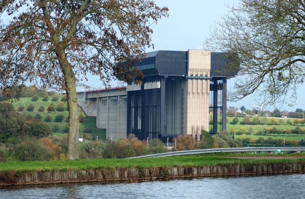 A concrete behemoth of a building, with what looks like a bridge extending to its upper end.