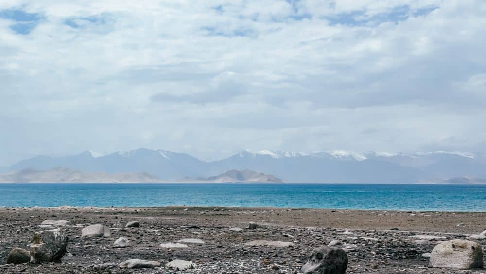 A view over a blue lake - on the other side in the distance, high snow-capped mountains.