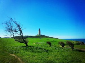 A distant view of the Tower of Hercules, looking up a hill at it.