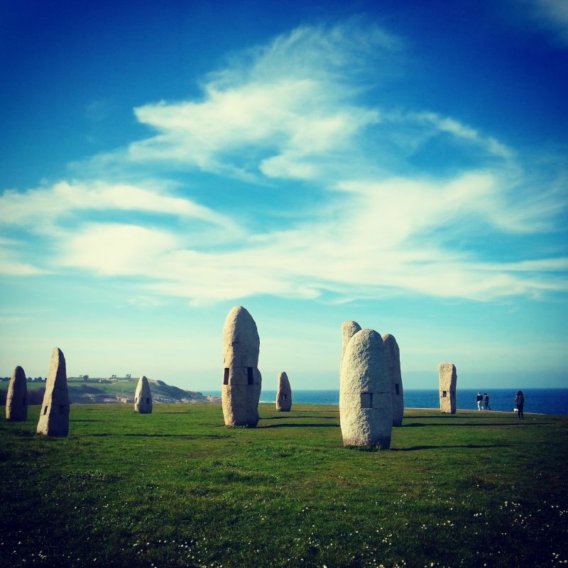 Large stone artworks scattered over a grassy field.