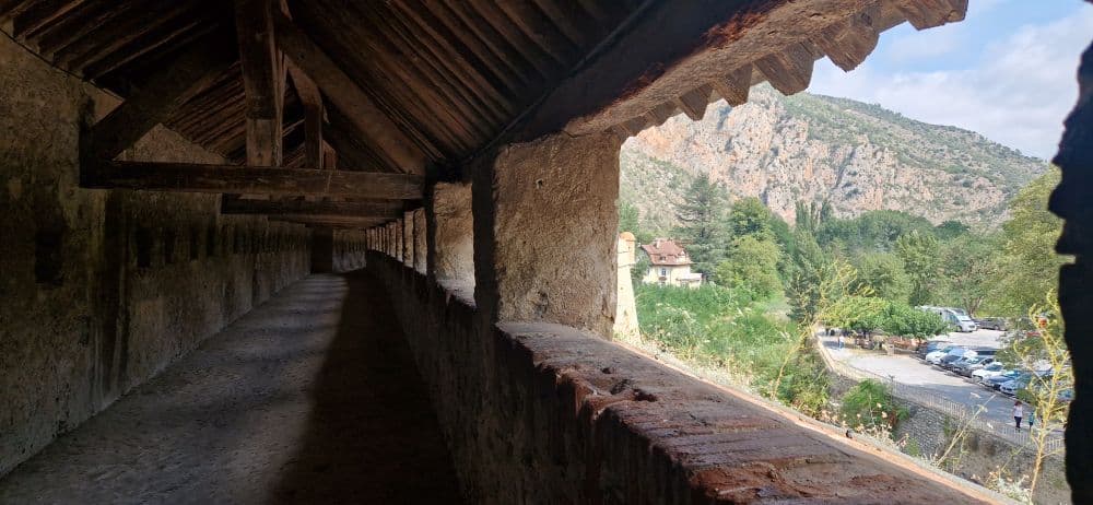 A long roofed walk, open to the countryside on one side.