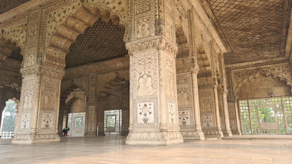 A pavilion, roofed but with open sides. The pillars and ceiling are inlayed with flower designs.