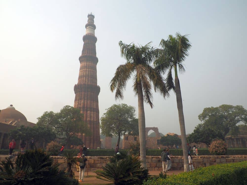 Several ruins in a garden-like setting, with a very tall tower.