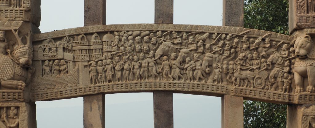 A bas-relief showing an army of men with elephants and a city.