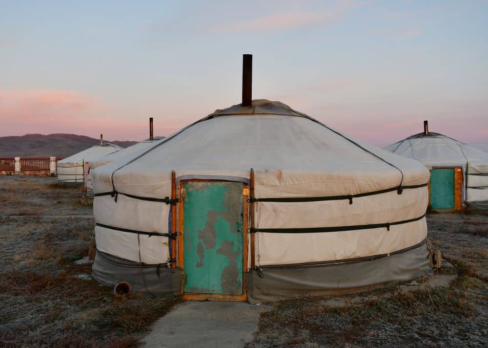 A yurt: a low, round building with cloth sides and roof.