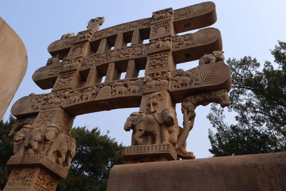 The gateway has two vertical supports and three crossbars, all carved with bas-relief figures.