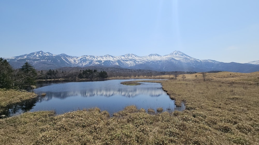 A lake in the foreground, snow-capped mountains in the background.