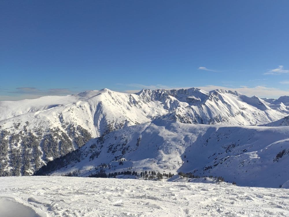 A mountainous landscape covered in a thin layer of snow.