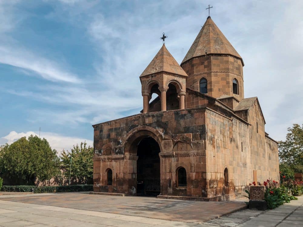 A small church with a multi-sided dome in its center with a pointed top. 