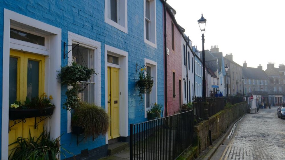 A row of two-story houses painted in bright colors.