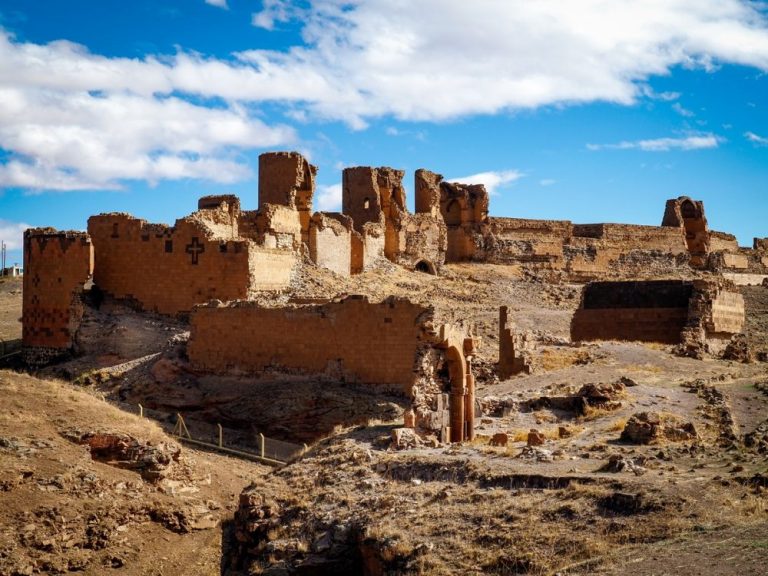 A series of ruins along the top of a hill.