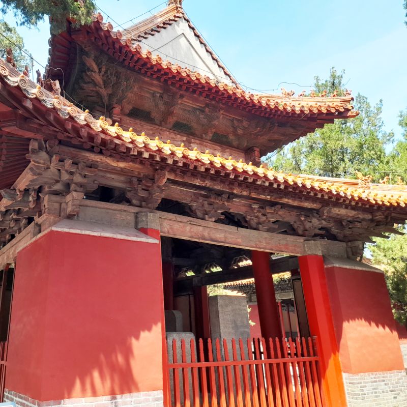 A small red temple with two traditional curved tile roofs.