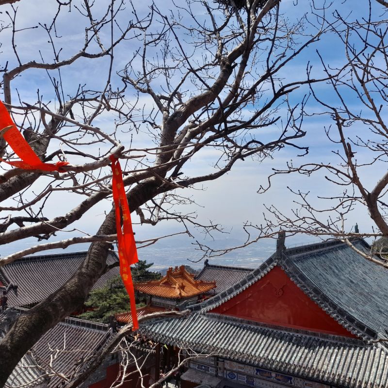 Looking down on a temple, with a big view far below in the distance.