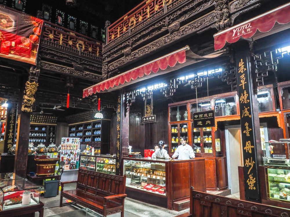 An exhibit that looks like a shop with wood shelving and cases filled with items.