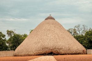A large conical structure covered with thatch all the way to the ground.