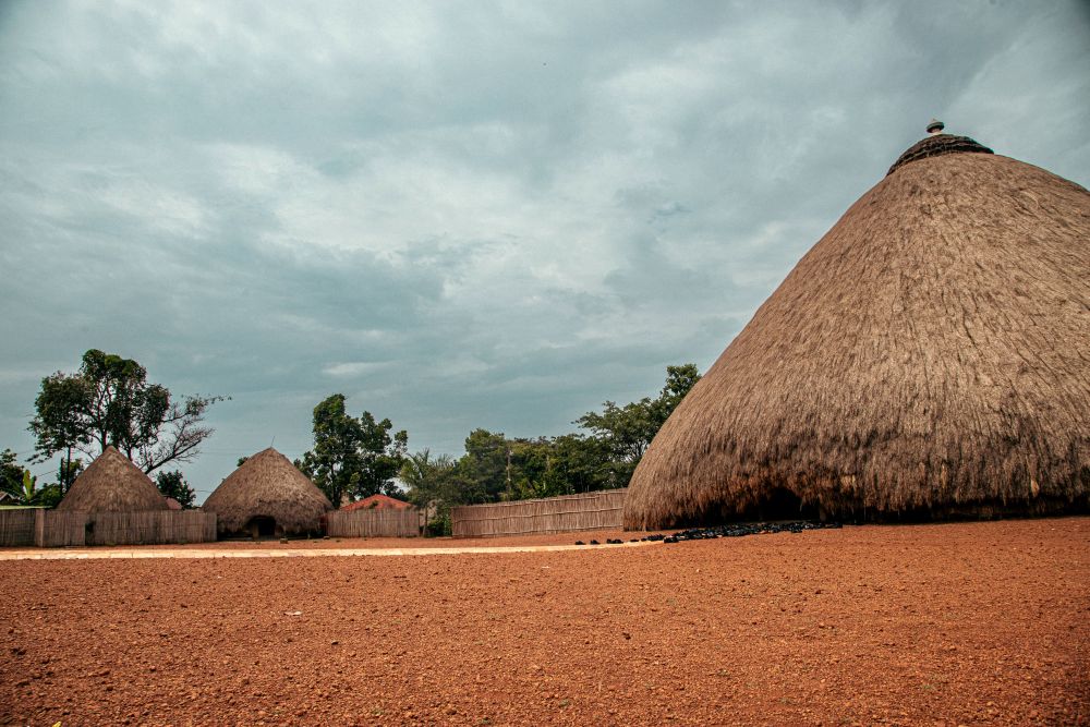 Looking past a conical thatched building to a few others that look the same in the background.