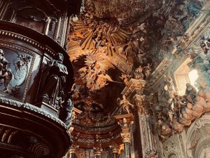 Incredibly ornate archway and ceiling: very baroque with sculpture and painting.