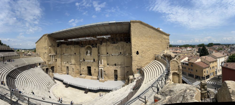 A view from high up on the seating shows the theatre backdrop and some of the city behind it.
