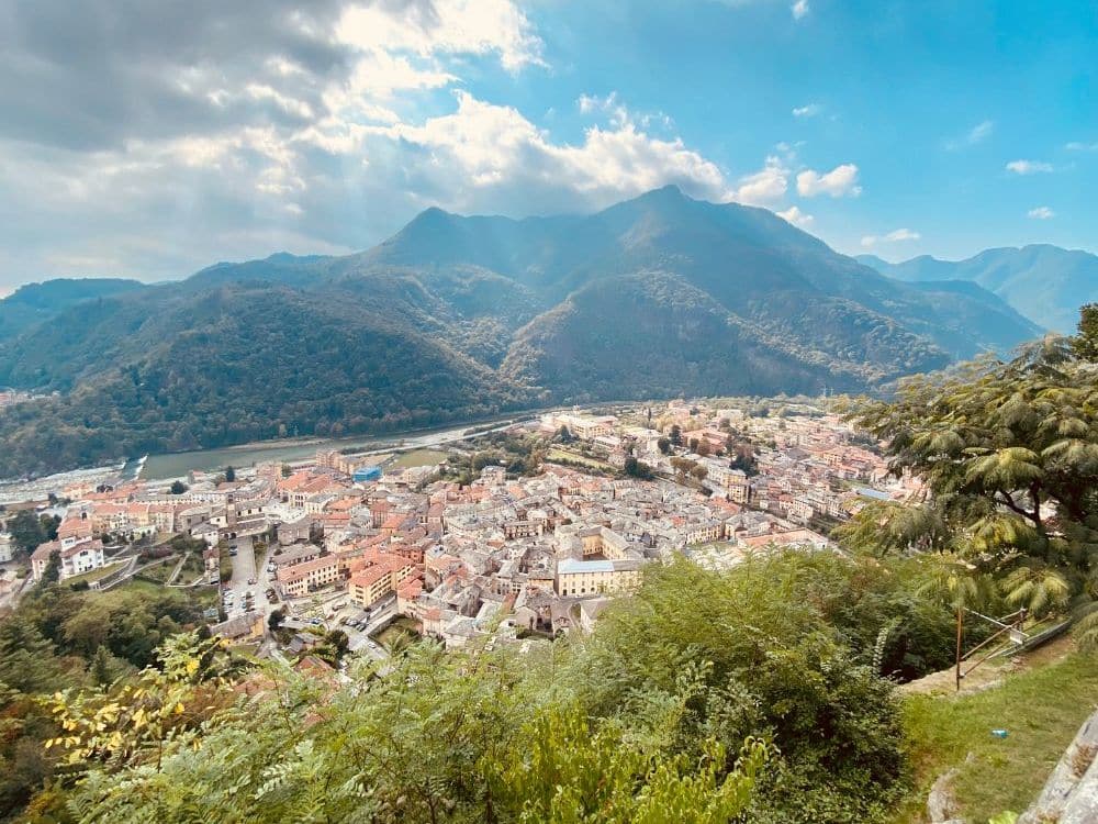 View over a town in a valley with picturesque mountains beyond that.