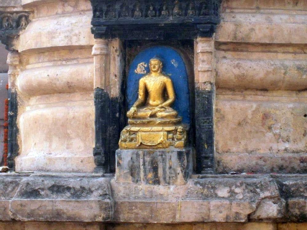 A close-up of a gold-painted sitting buddha statue.