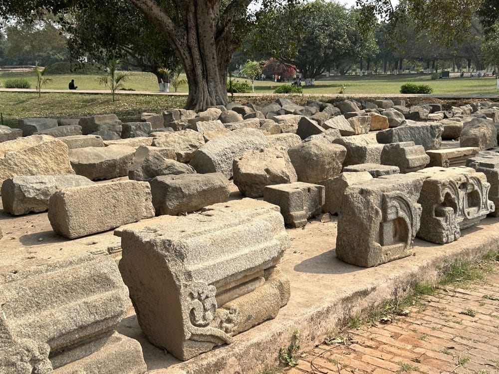 Blocks from the ruins, set in neat rows. Some have carved decorations on them.
