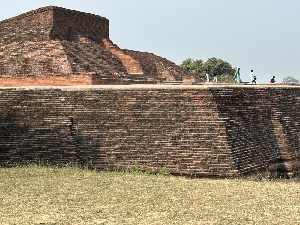 A brick structure, with a high brick platform - the people walking on it show that it is perhaps 3 stories high, with a pyramid-like structure on top of that.