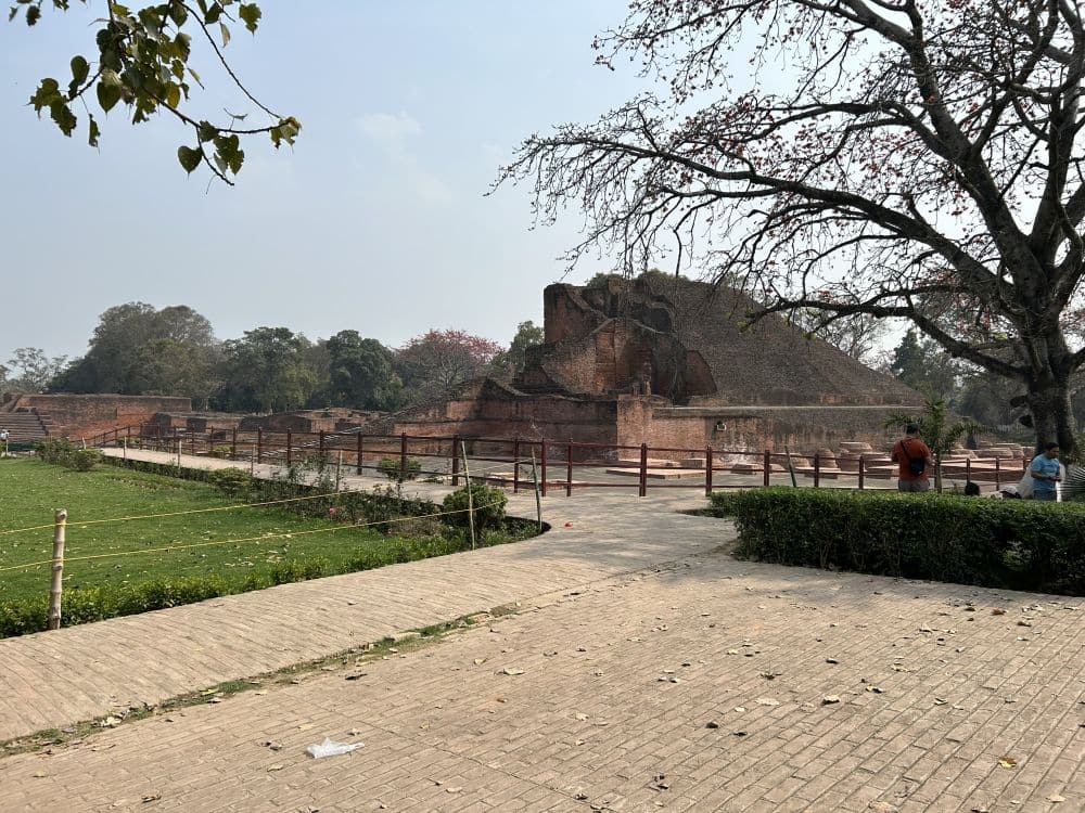 A view of a ruined stupa in the distance.
