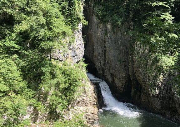 A waterfall emerges from a narrow gorge.