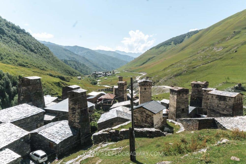 View of an Upper Svaneti village with stone towers seen from above the village looking down the valley.