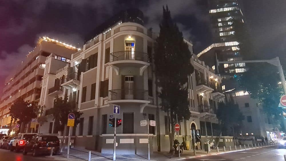 4-story building on a street corner, with, on the building corner, balconies with wrought-iron railings.