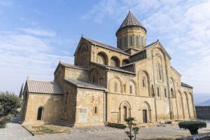 A large church with arches and a round tower in its center.