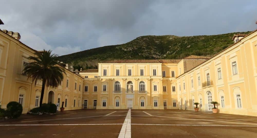 A stately 3-story building around 3 sides of a courtyard.