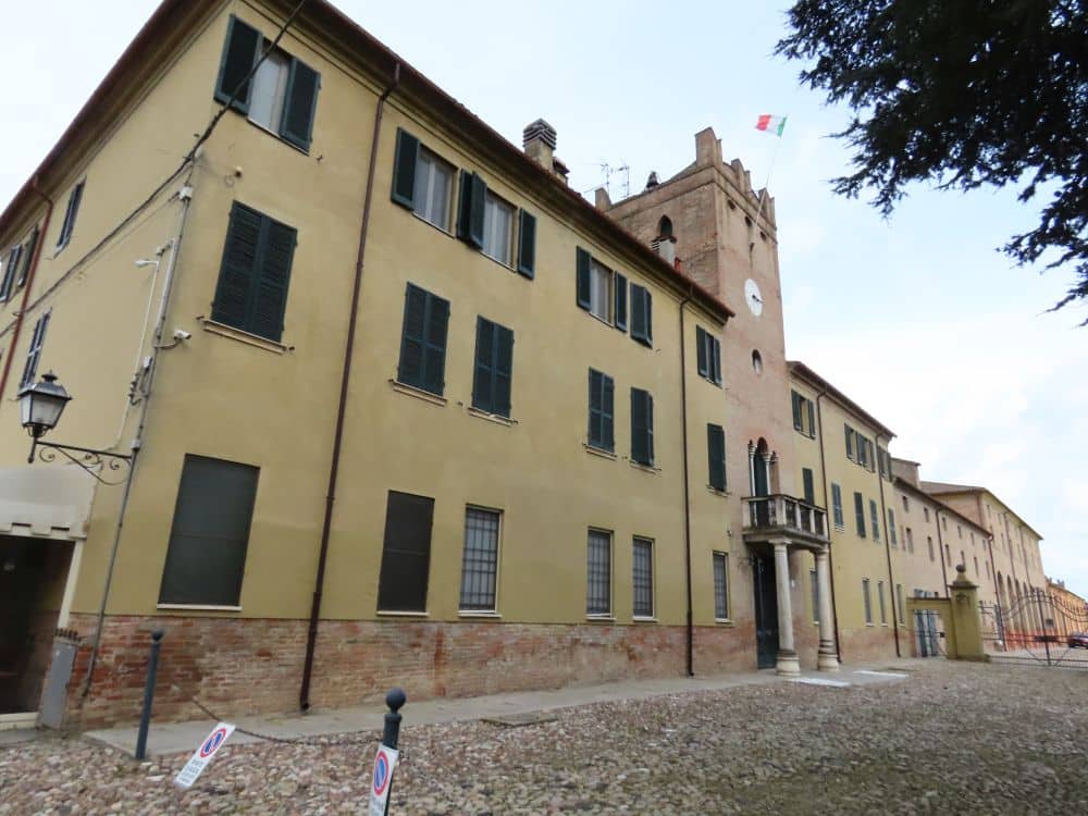 A large, long building of 3 stories with a tower emerging from its center.