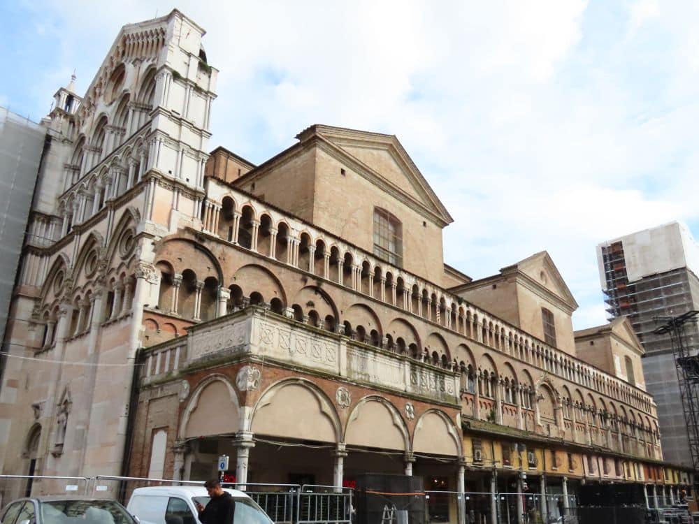 A long church with a portico along its side in Romanesque arches.