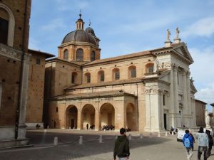 The church as a neo-classical front and rounded arches along the side. Behind is the dome of the church.