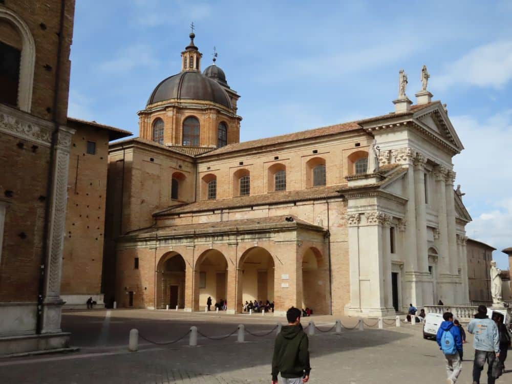 The church as a neo-classical front and rounded arches along the side. Behind is the dome of the church.