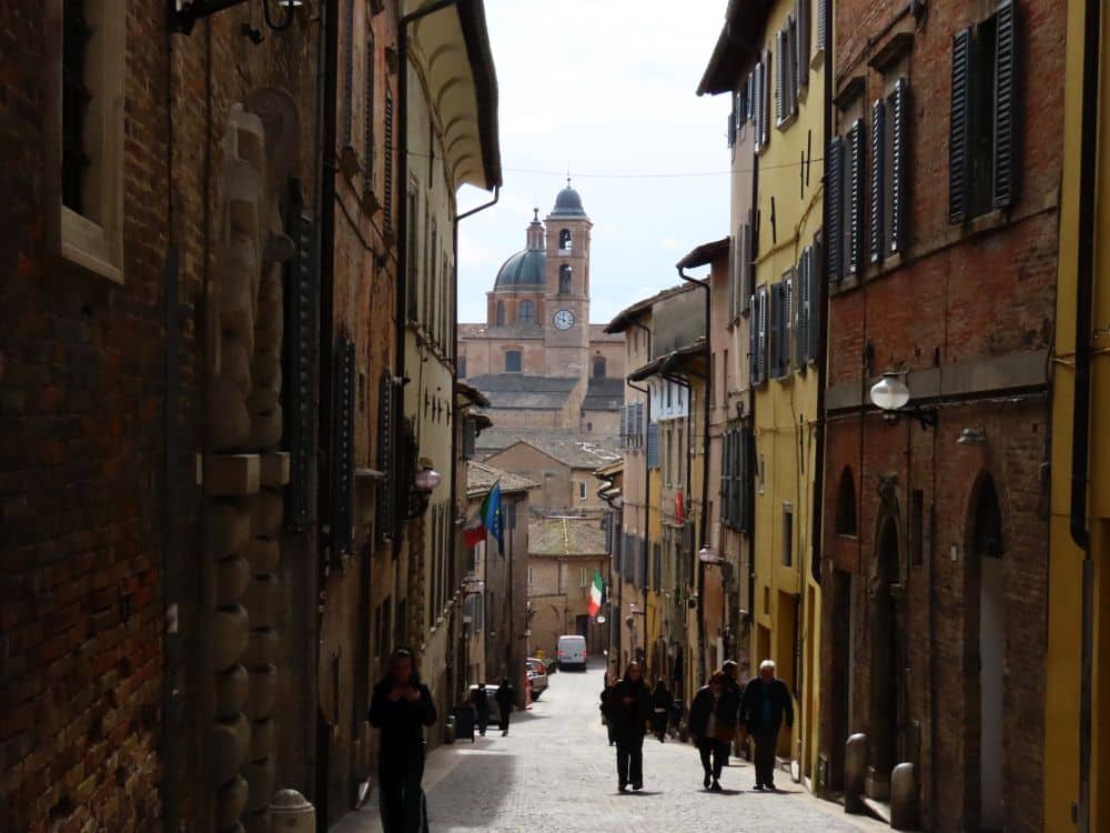 View down a narrow street, the basilica visible in the distance.
