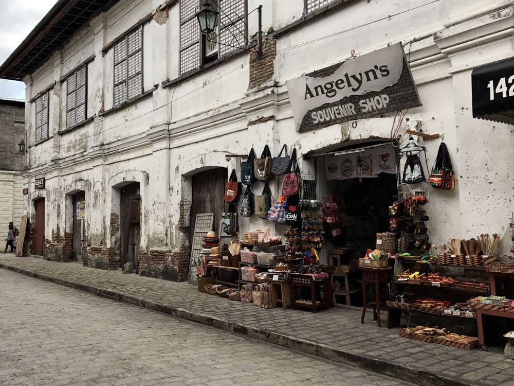 A souvenir shop "Angelyn's Souvenir Shop" on the ground floor of a two-story building that looks rather rundown.