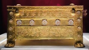 A gold box with flowers embossed on it and lion-paw shaped feet.